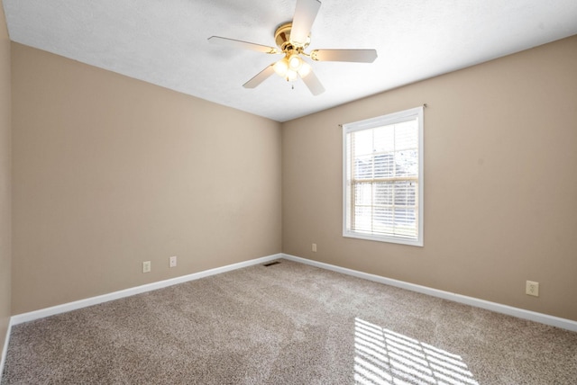 carpeted spare room featuring ceiling fan