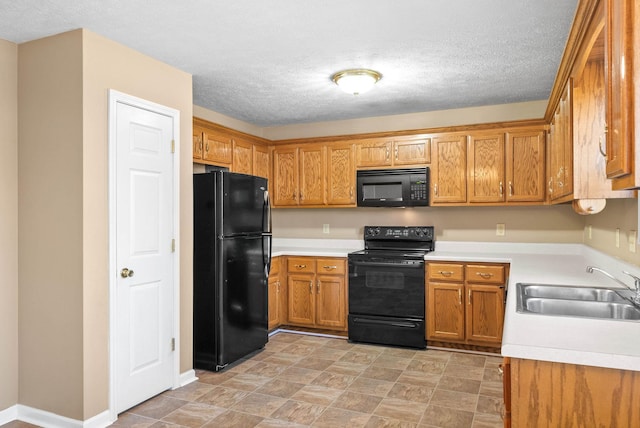 kitchen featuring sink, black appliances, and a textured ceiling