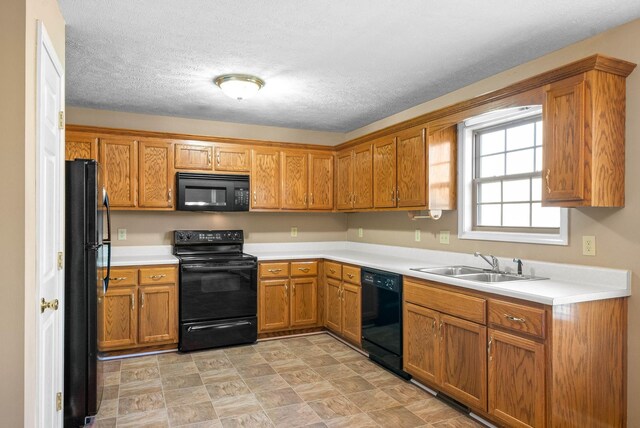 kitchen with black appliances, sink, and a textured ceiling