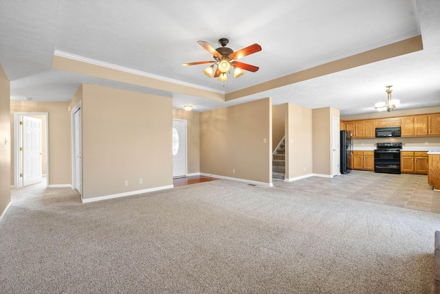 unfurnished living room featuring ornamental molding, light carpet, and a tray ceiling