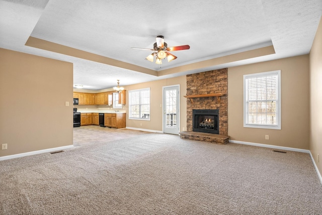 unfurnished living room with plenty of natural light, light colored carpet, and a tray ceiling