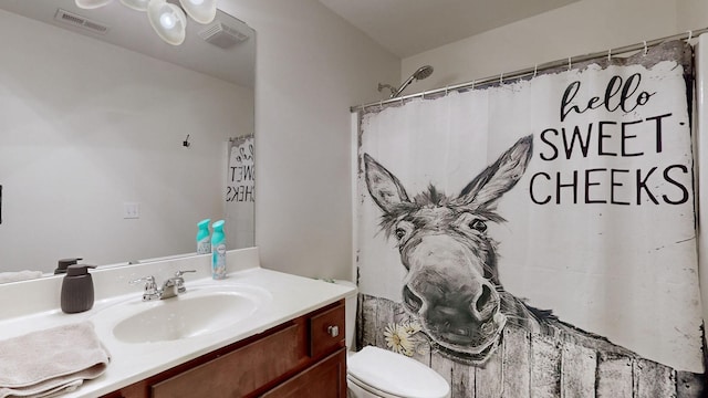 bathroom with vanity, curtained shower, and toilet