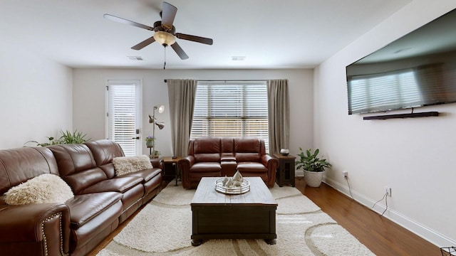 living room with ceiling fan and dark hardwood / wood-style flooring