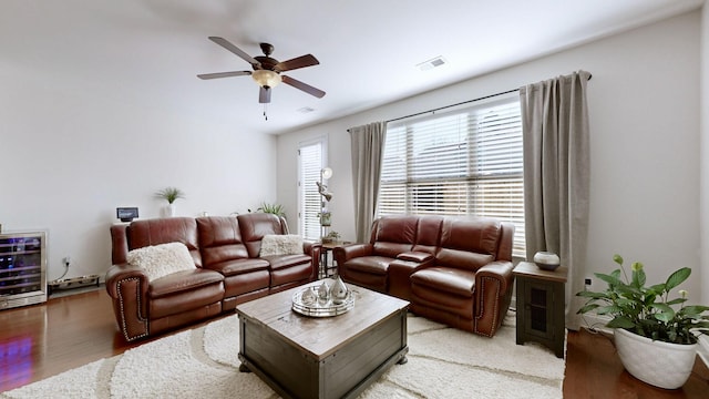 living room with hardwood / wood-style flooring, wine cooler, and ceiling fan