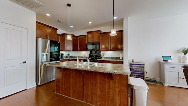 kitchen with sink, dark hardwood / wood-style floors, decorative light fixtures, stainless steel fridge with ice dispenser, and beverage cooler