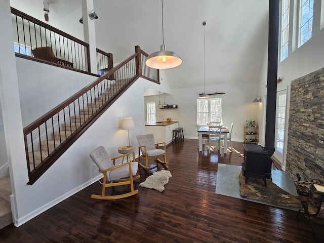 interior space with dark hardwood / wood-style floors, a wood stove, and a high ceiling