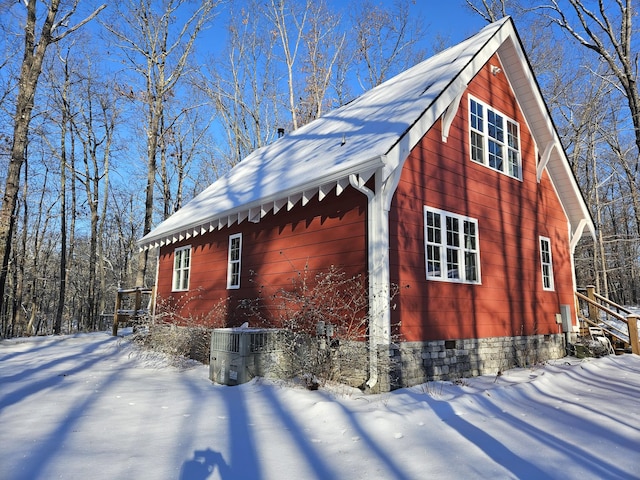 view of snowy exterior with central air condition unit