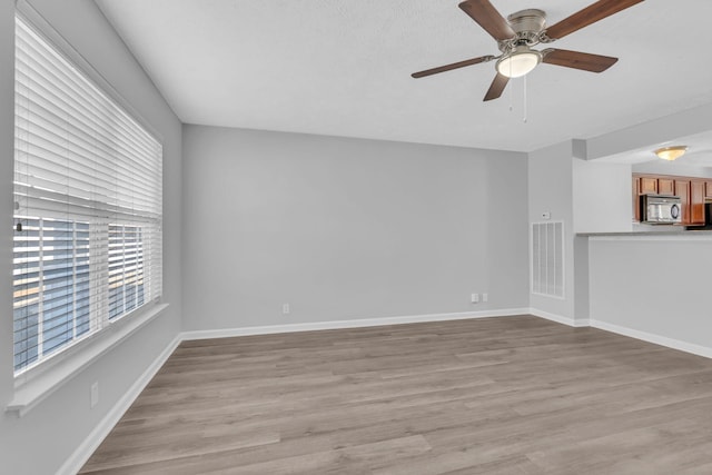 unfurnished living room featuring ceiling fan and light hardwood / wood-style flooring