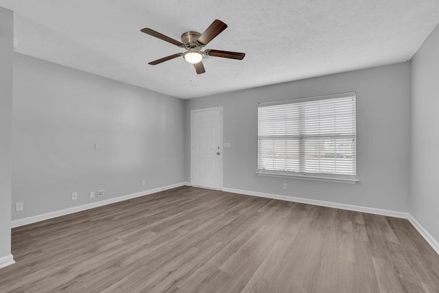 unfurnished room featuring a textured ceiling, light hardwood / wood-style floors, and ceiling fan