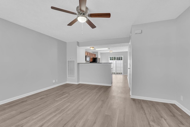 unfurnished living room with light wood-type flooring and ceiling fan