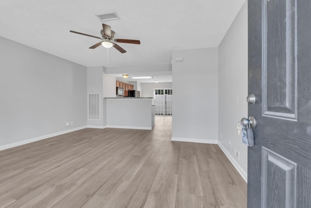 unfurnished living room with ceiling fan and light wood-type flooring