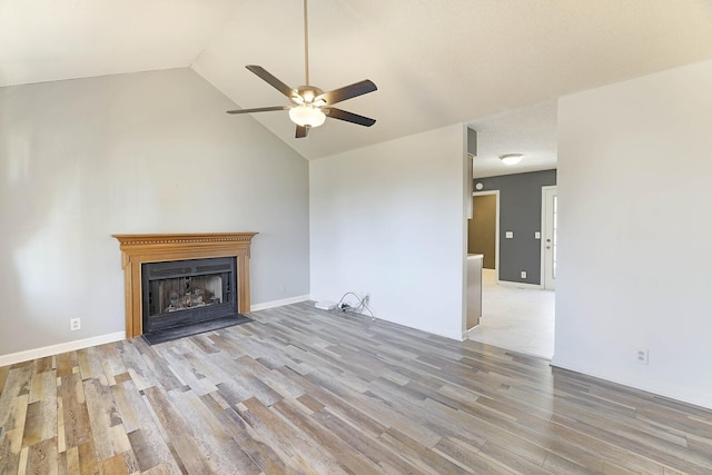 unfurnished living room featuring ceiling fan, lofted ceiling, and light wood-type flooring