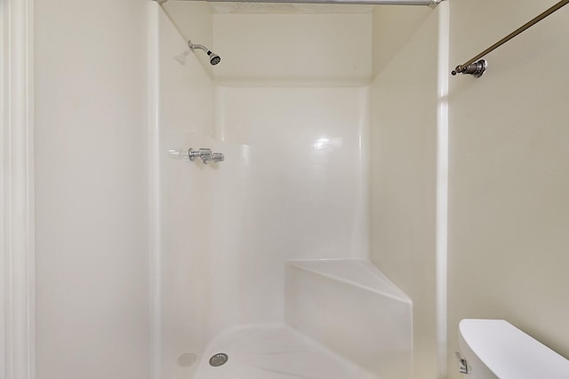 bathroom featuring a shower and toilet