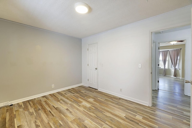 empty room featuring a textured ceiling and light hardwood / wood-style floors