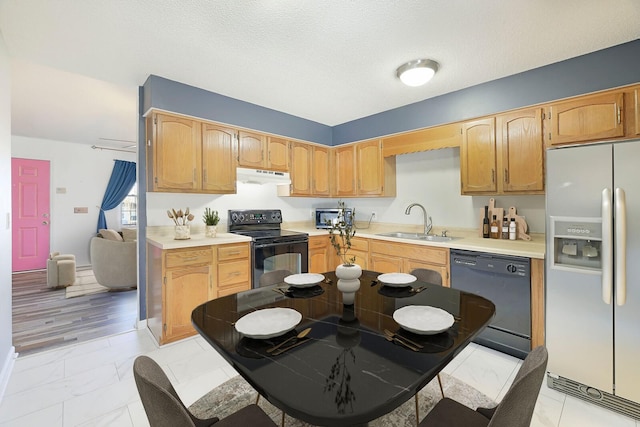 kitchen featuring sink, black appliances, and a textured ceiling