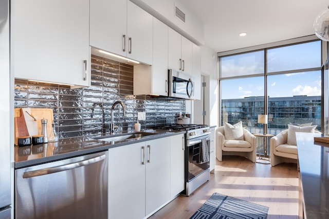 kitchen featuring sink, stainless steel appliances, hardwood / wood-style floors, and white cabinets