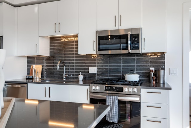 kitchen with backsplash, stainless steel appliances, sink, and white cabinets