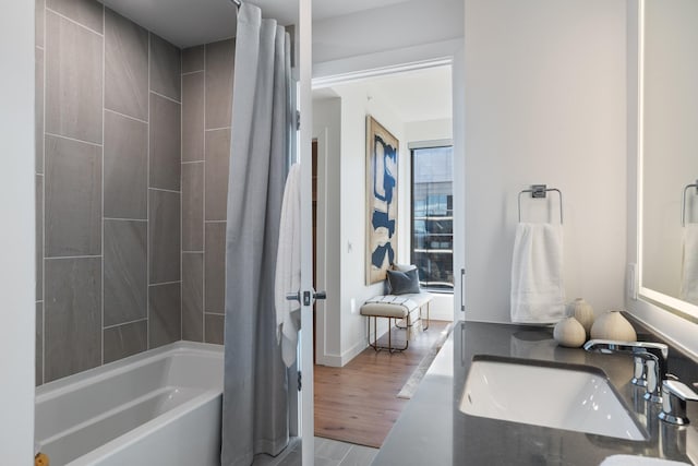 bathroom with sink, hardwood / wood-style floors, and shower / tub combo with curtain