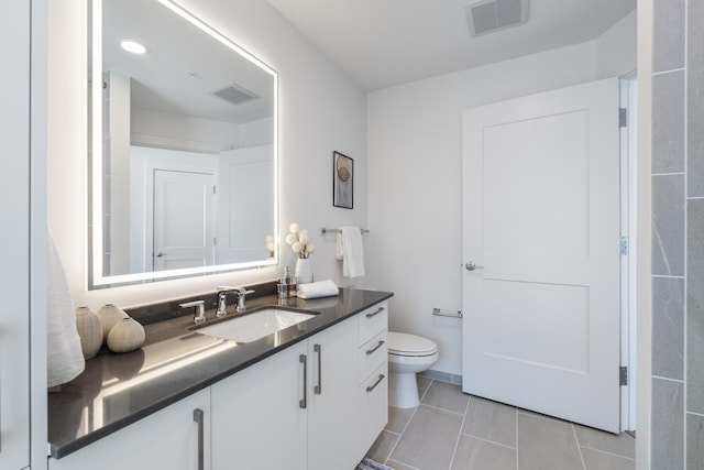 bathroom featuring tile patterned floors, vanity, and toilet