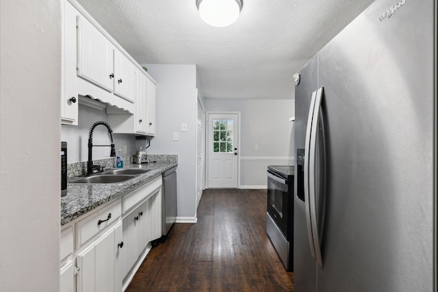 kitchen with light stone countertops, sink, stainless steel appliances, dark hardwood / wood-style floors, and white cabinets