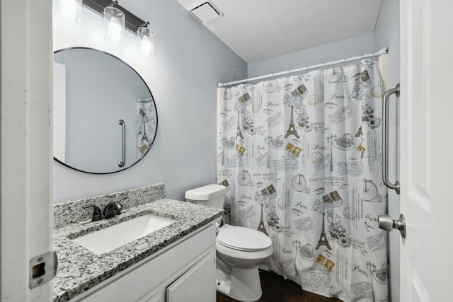 bathroom featuring curtained shower, vanity, a textured ceiling, and toilet