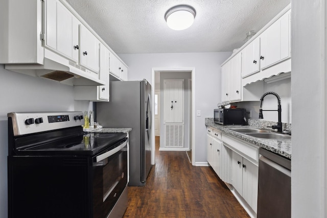 kitchen featuring sink, dark wood-type flooring, stainless steel appliances, a textured ceiling, and white cabinets