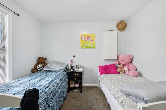 bedroom featuring a textured ceiling and dark carpet