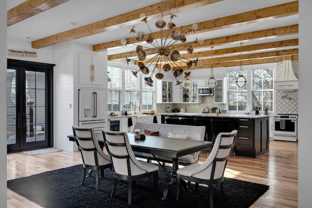 dining room with beamed ceiling, french doors, and light hardwood / wood-style floors