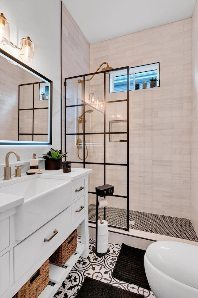 bathroom featuring tile patterned floors, vanity, and a tile shower