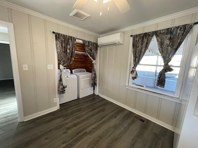 interior space with crown molding, ceiling fan, washing machine and dryer, dark hardwood / wood-style flooring, and a wall unit AC