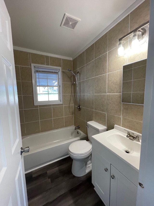 full bathroom with tiled shower / bath combo, wood-type flooring, toilet, vanity, and tile walls