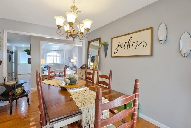 dining area featuring light hardwood / wood-style floors and an inviting chandelier