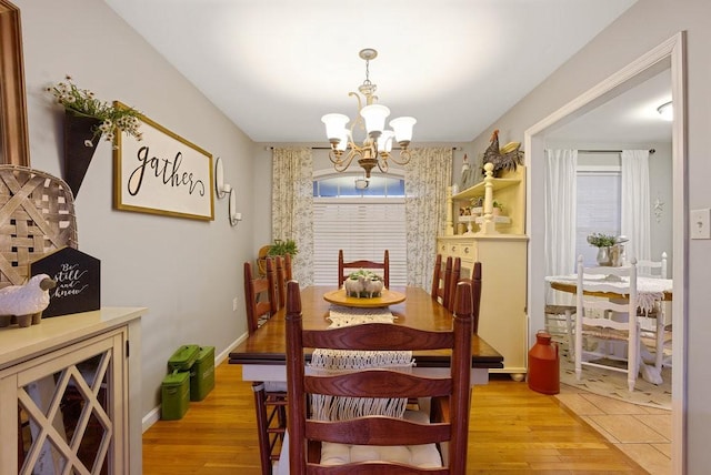 dining area featuring light wood-type flooring and an inviting chandelier