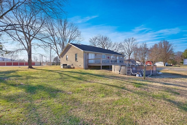 back of house with a lawn and a pool side deck