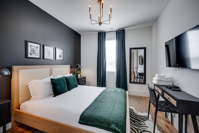 bedroom featuring hardwood / wood-style floors and an inviting chandelier