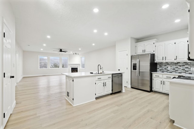 kitchen with sink, ceiling fan, an island with sink, appliances with stainless steel finishes, and white cabinetry