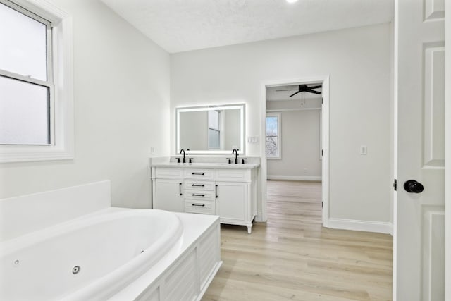 bathroom featuring a bathtub, a textured ceiling, vanity, ceiling fan, and hardwood / wood-style floors