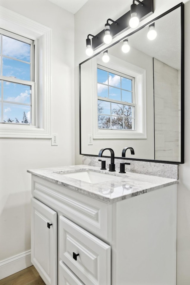 bathroom with hardwood / wood-style floors, vanity, and a wealth of natural light