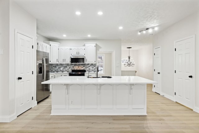 kitchen featuring a kitchen island with sink, sink, white cabinets, and appliances with stainless steel finishes