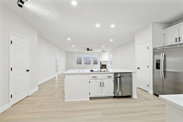 kitchen with stainless steel appliances, ceiling fan, sink, light hardwood / wood-style flooring, and white cabinets