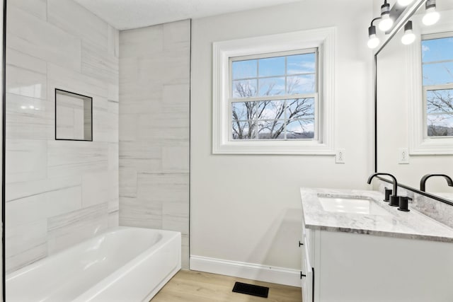 bathroom with hardwood / wood-style floors, vanity, and a bathtub