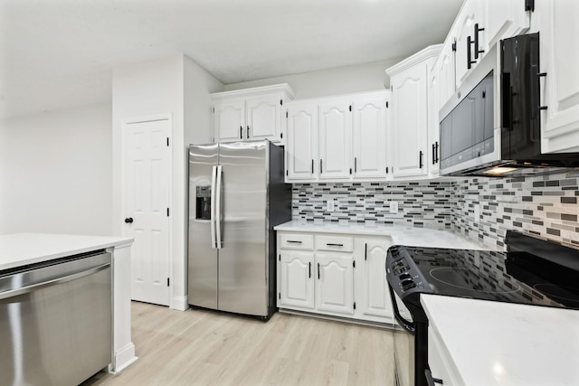 kitchen with decorative backsplash, white cabinets, light wood-type flooring, and appliances with stainless steel finishes