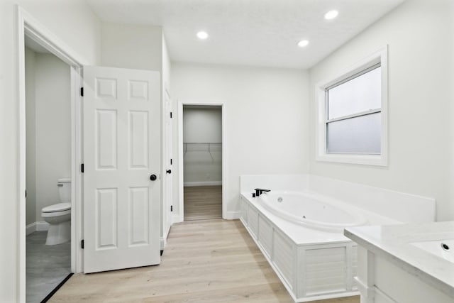 bathroom with vanity, hardwood / wood-style flooring, toilet, and a bathing tub