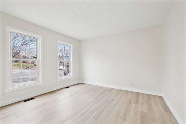 unfurnished room with light wood-type flooring