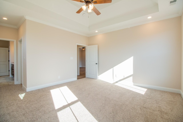 unfurnished bedroom with ceiling fan, a raised ceiling, light carpet, and crown molding