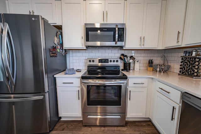 kitchen with backsplash, appliances with stainless steel finishes, dark hardwood / wood-style floors, and white cabinets