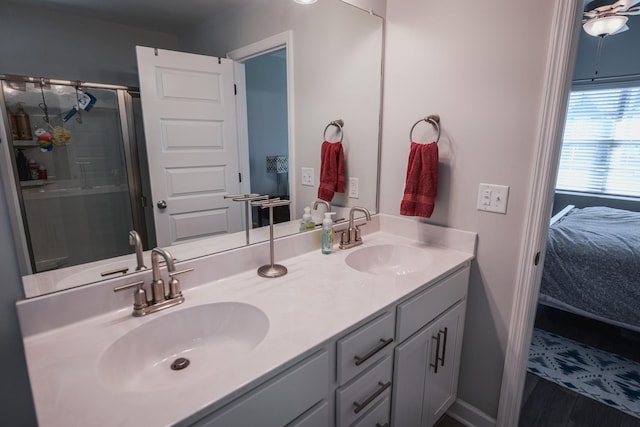 bathroom with vanity, hardwood / wood-style flooring, and a shower with door