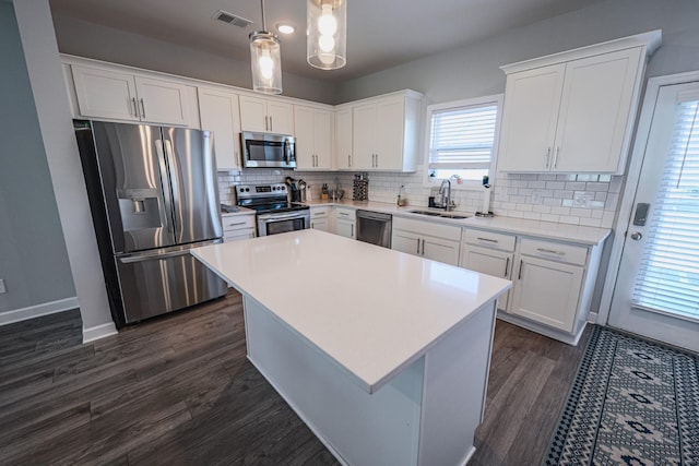 kitchen featuring pendant lighting, sink, white cabinets, and appliances with stainless steel finishes