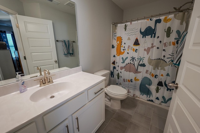 bathroom with vanity, tile patterned flooring, toilet, and walk in shower