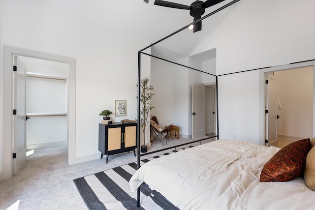 carpeted bedroom with ceiling fan and high vaulted ceiling